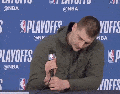 Jokic breaking a microphone on the podium after a game.